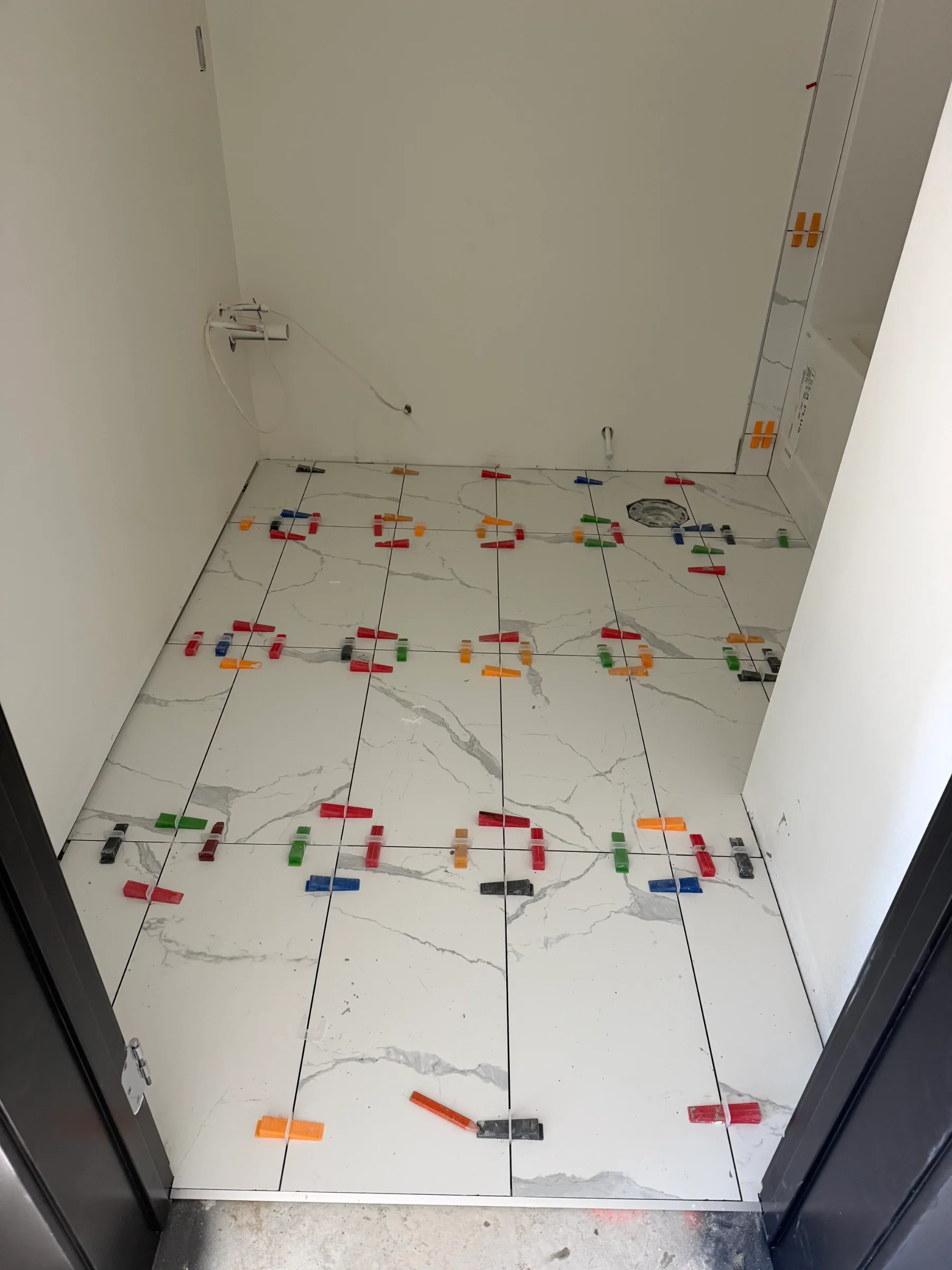 Large format floor tile installation with leveling system in Calgary